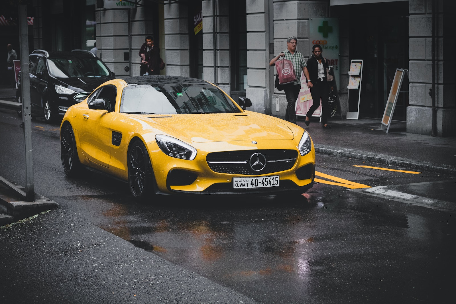 Mercedes-Benz coupe on asphalt road near concrete building